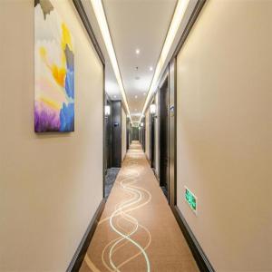 a long hallway with a painting on the wall at Xana Hotelle Tianjin Binjiang Road Heping Road Metro Station Quanyechang in Tianjin