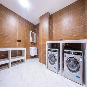 a bathroom with two washing machines in a room at Xana Hotelle Tianjin Binjiang Road Heping Road Metro Station Quanyechang in Tianjin