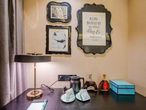 a desk with a lamp and a sign on a wall at Xana Hotelle Tianjin Binjiang Road Heping Road Metro Station Quanyechang in Tianjin