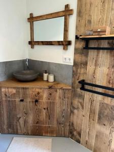 La salle de bains en bois est pourvue d'un lavabo et d'un miroir. dans l'établissement Hello Noordwijk - Studio Pietheinplein 1, à Noordwijk aan Zee