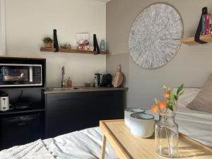 - une cuisine avec une table et un four micro-ondes dans la chambre dans l'établissement Hello Noordwijk - Studio Pietheinplein 1, à Noordwijk aan Zee