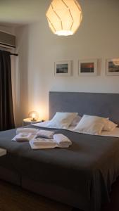 ein Schlafzimmer mit einem großen Bett mit Handtüchern darauf in der Unterkunft Pine House - Faro Airport, Beach and City Center in Faro