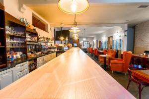 eine Bar mit einer langen Holztheke in einem Restaurant in der Unterkunft Penzión Ľadoveň SKVELÁ KUCHYŇA A RODINNÁ ATMOSFÉRA in Martin