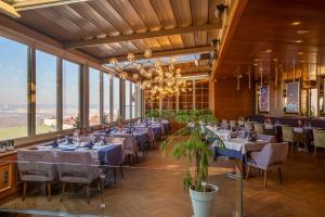 a dining room with tables and chairs and windows at Marigold Thermal & Spa Hotel Bursa in Bursa