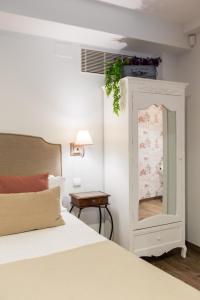 een slaapkamer met een wit bed en een spiegel bij Le Petit Apartamentos in Santander