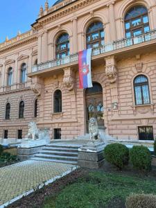 een gebouw met een vlag ervoor bij DANA GUEST HOUSE in Sremski Karlovci