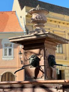 een fontein met twee leeuwenkoppen erop bij DANA GUEST HOUSE in Sremski Karlovci