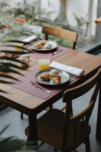 una mesa de madera con platos de comida y un vaso de zumo de naranja en NINE DOTS Azorean Art Boutique Hotel, en Ponta Delgada