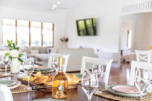 tavolo da pranzo con bottiglia di vino e bicchieri di The Hampton Lodge a Port Douglas