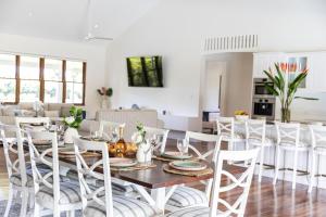 una sala da pranzo e un soggiorno con tavolo e sedie. di The Hampton Lodge a Port Douglas