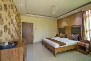 a bedroom with a large bed and a desk at Parnil Palace in Guwahati