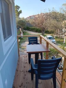 a wooden deck with a table and chairs on it at Tolis Rooms in Himare