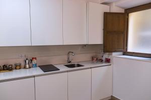 a kitchen with white cabinets and a sink at BELIA A.T. in Cáceres