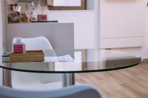 a glass table with a chair and a bottle of glue at BELIA A.T. in Cáceres