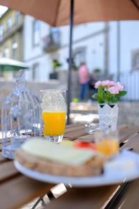 une table avec un verre de jus d'orange et un sandwich dans l'établissement Hotel Os Poetas, à Ponte da Barca