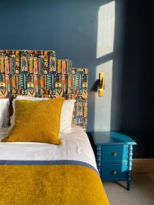 un letto con testiera colorata e tavolo blu di Fellpack House a Keswick