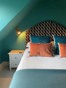 una camera da letto con un letto con cuscini blu e arancioni di Fellpack House a Keswick