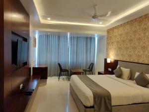 a hotel room with a large bed and a table at KAMAT'S DAFFODIL RESORT GOA in Pilerne