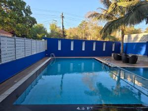 a swimming pool with blue walls and a blue fence at KAMAT'S DAFFODIL RESORT GOA in Pilerne