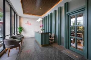 uma sala de espera com paredes verdes e cadeiras em ValStar Hotel Canggu em Canggu