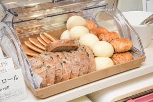 uma vitrine com vários tipos de pão e pastelaria em Vessel Inn Chiba Ekimae em Chiba