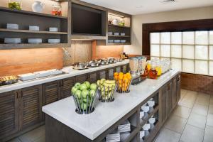 une cuisine avec un comptoir avec des fruits et légumes en vases dans l'établissement Hyatt House Boston Waltham, à Waltham