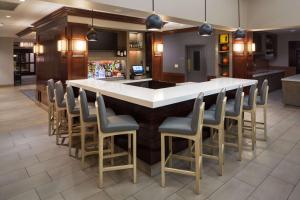 un bar dans un restaurant avec des chaises autour de lui dans l'établissement Hyatt House Boston Waltham, à Waltham