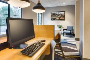 un bureau avec un écran d'ordinateur et un clavier sur un bureau dans l'établissement Hyatt House Boston Waltham, à Waltham