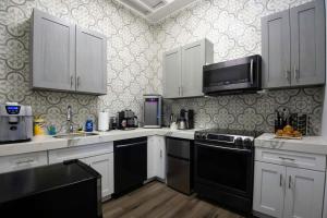 新奥尔良5 BR - Sleeps 10! Best Location next to French Quarter!的厨房配有白色橱柜和黑色家电