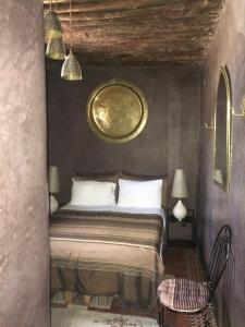 een slaapkamer met een bed en een stoel erin bij Riad Marhaba in Rabat