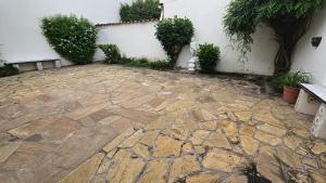 a stone patio with plants and a white wall at La Merced in Salta