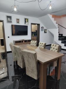 a dining room with a wooden table and chairs at Black&White House in Ocna-Mureşului