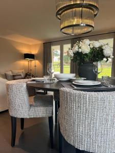 une table à manger avec des chaises et un vase de fleurs dans l'établissement Appartement ALLURE 4 Zimmer Gartenwohnung, à Eschen