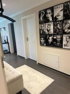 - un salon avec un canapé et un mur avec des affiches de cinéma dans l'établissement Appartement ALLURE 4 Zimmer Gartenwohnung, à Eschen