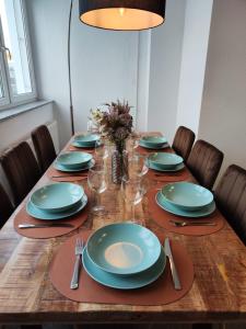 a wooden table with plates and wine glasses on it at * Wohlfühloase Köln I * in Cologne