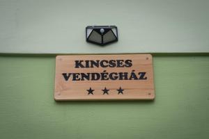 un cartel en una pared verde que lee "Kings Vanderbilt" en Kincses Vendégház, en Senta