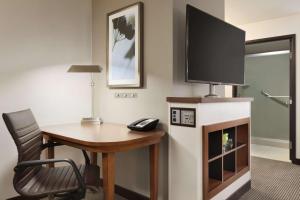 een kamer met een bureau en een tv op een open haard bij Hyatt Place Portland Airport/Cascade Station in Portland