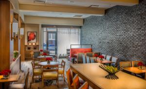 un restaurant avec des tables et des chaises et un mur en briques dans l'établissement Hyatt Place Baltimore Inner Harbor, à Baltimore