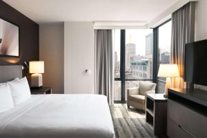 ein Hotelzimmer mit einem Bett und einem großen Fenster in der Unterkunft Hyatt House New York/Chelsea in New York