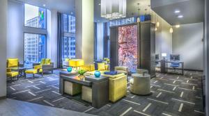 - un hall avec des tables et des chaises jaunes et de grandes fenêtres dans l'établissement Hyatt Place Washington D.C./National Mall, à Washington