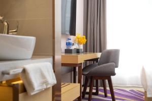 a bathroom with a sink and a desk with a chair at Guangzhou Baiyun Airport Yunzhi Hotel near Terminal One - Complimentary Shuttle Bus between hotel to Canton Fair Complex during Canton Fair in Guangzhou