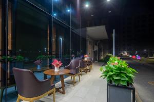 a row of chairs and tables on the side of a building at Guangzhou Baiyun Airport Yunzhi Hotel near Terminal One - Complimentary Shuttle Bus between hotel to Canton Fair Complex during Canton Fair in Guangzhou