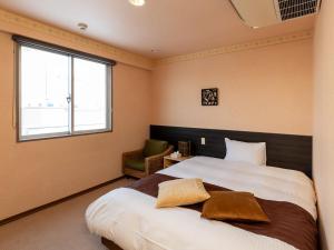 Tabist Hirosaki Touei Hotel tesisinde bir odada yatak veya yataklar