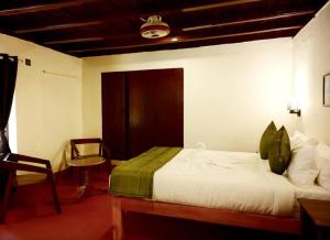 una camera con letto, tavolo e sedia di Coorg Mystere - Luxury Homestay a Madikeri