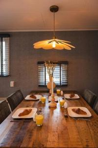 a dining room table with plates of food on it at Chalet op familiepark Veluws Hof op de Hoge Veluwe in Hoenderloo