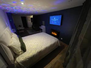 - une chambre avec un lit et une télévision murale dans l'établissement ZEN & SPA, à Givet