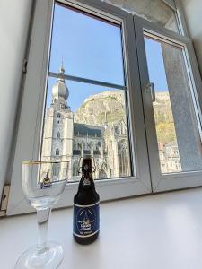 a bottle of wine sitting next to a window with a wine glass at NOMAD APARTMENTS - Astrid in Dinant