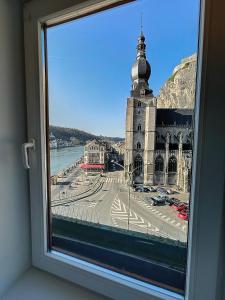 a window with a view of a city and a church at NOMAD APARTMENTS - Astrid in Dinant