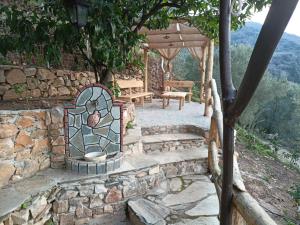 a stone patio with a bench and a stone wall at Ελαιώνας - Solar Energy House in Chorefto