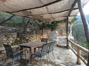 a wooden table and chairs on a patio at Ελαιώνας - Solar Energy House in Chorefto